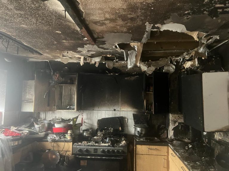 Kitchen severely damaged by fire, with charred cabinets, soot-covered surfaces, and debris scattered across countertops, illustrating the need for professional fire clean-up services.