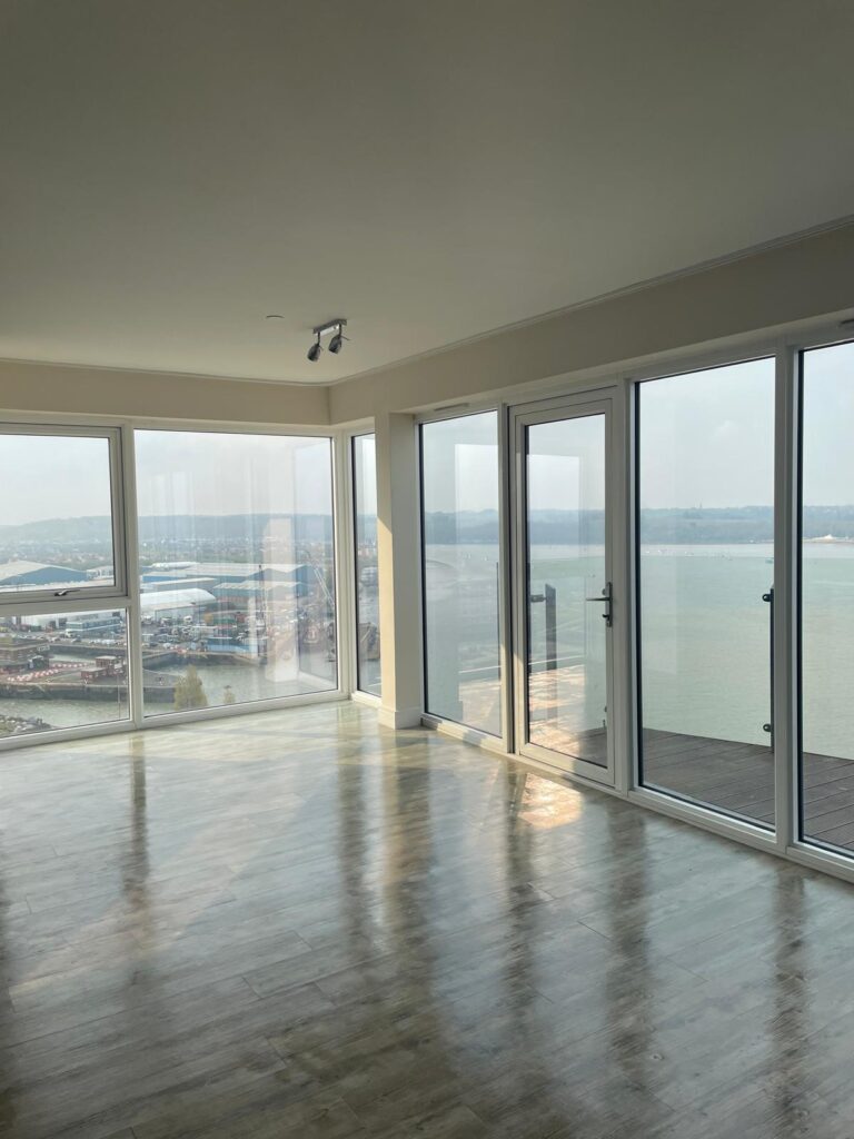 Spacious, modern room with large windows showcasing a waterfront view, ideal for end of tenancy cleaning in Kent.